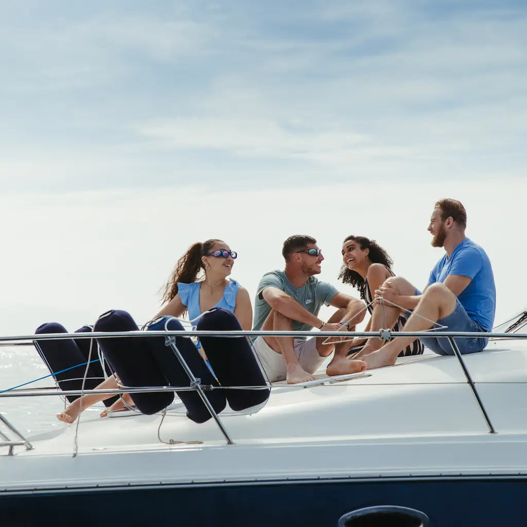 4 personnes sont sur un bateau en pleine mer avec 2 qui portent des lunettes anti-mal des transport