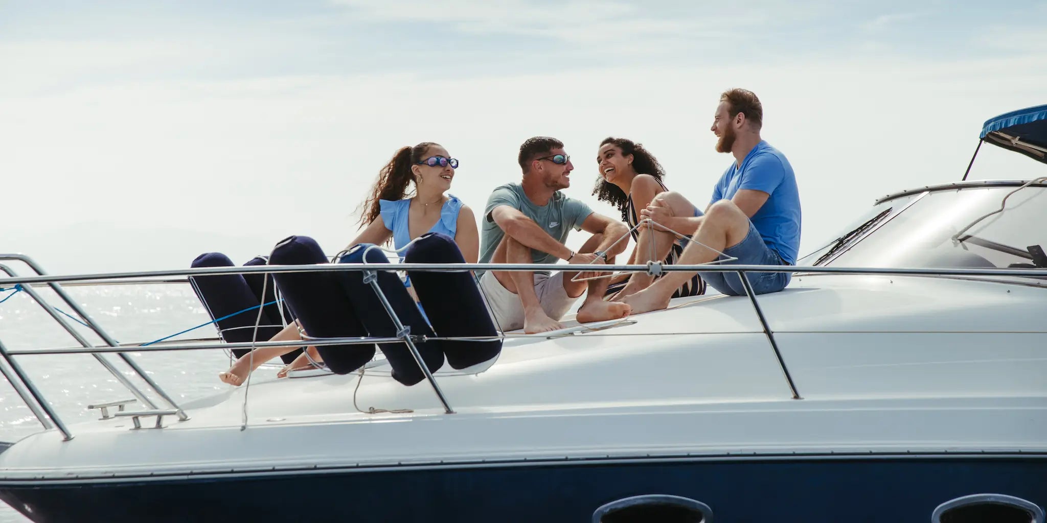 4 personnes sont sur un bateau en pleine mer avec 2 qui portent des lunettes anti-mal des transport